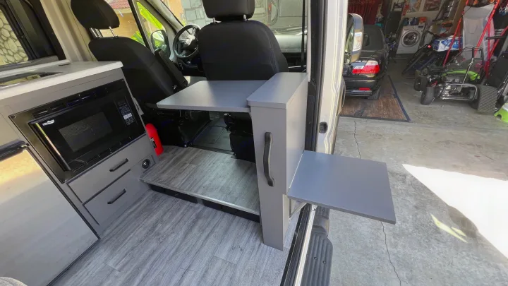 Custom rv rental van interior: kitchen with microwave, sink, and two retractable tables for versatile use.. Thor Dazzle 2024