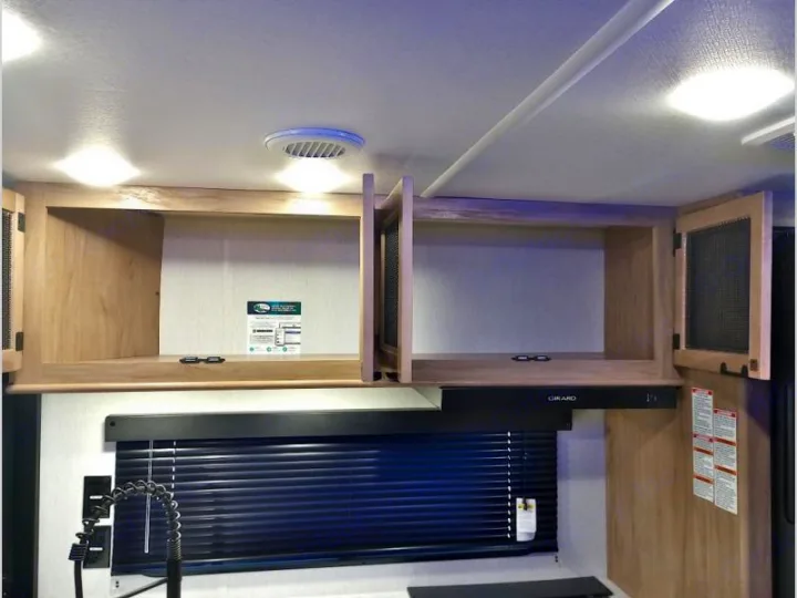 RV rental: Inside a well-lit kitchen with open wooden cabinets, sink, Girard range hood, and ceiling vent.. Forest River Cherokee Grey Wolf 2024