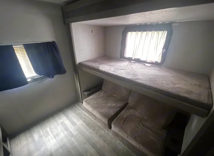 This RV rental features bunk beds: an upper sleeping area & lower sofa cushions that convert. Ideal for trips.. Forest River Vibe 2020