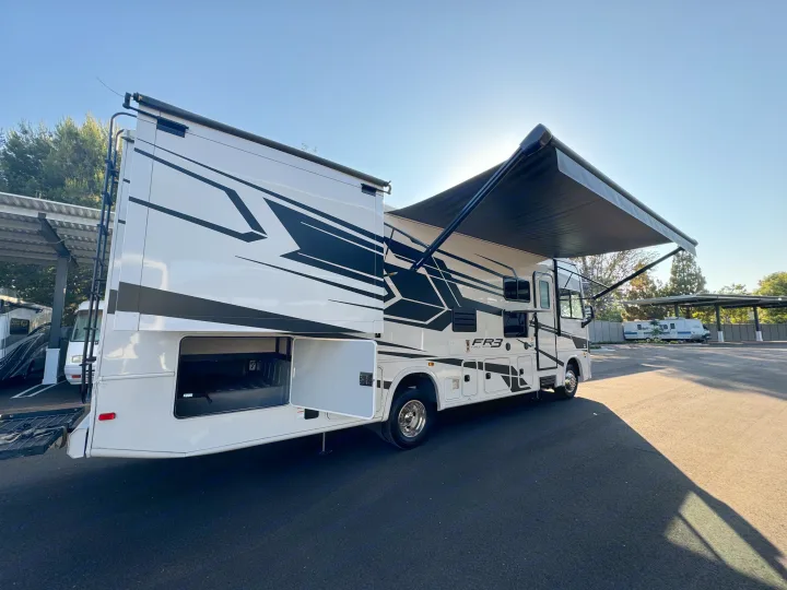 Bright white RV rental with slide-out and awning fully extended, showcasing ample storage.. Forest River Fr3 2021