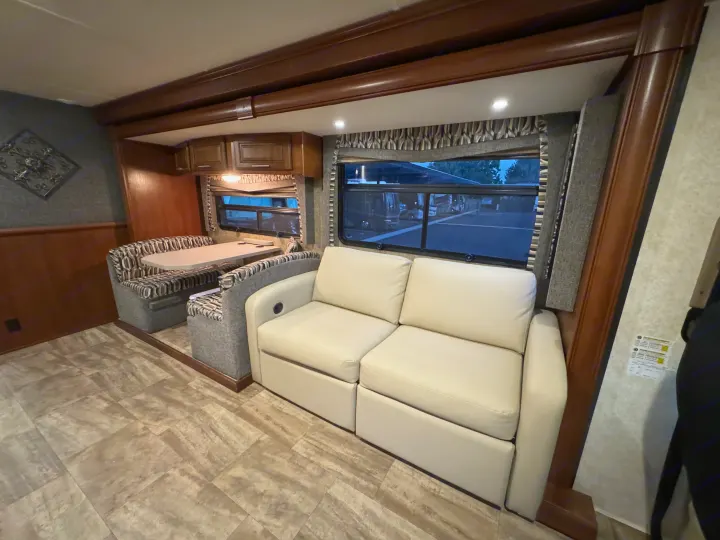 Spacious, modern RV rental interior with a comfy sofa, dining booth, and large windows. Perfect for road trips!. Forest River Georgetown 2018