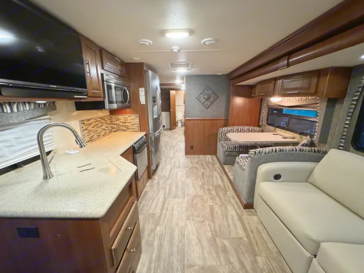 Spacious RV rental interior featuring a full kitchen, dining booth, and sofa for comfortable travel.. Forest River Georgetown 2018