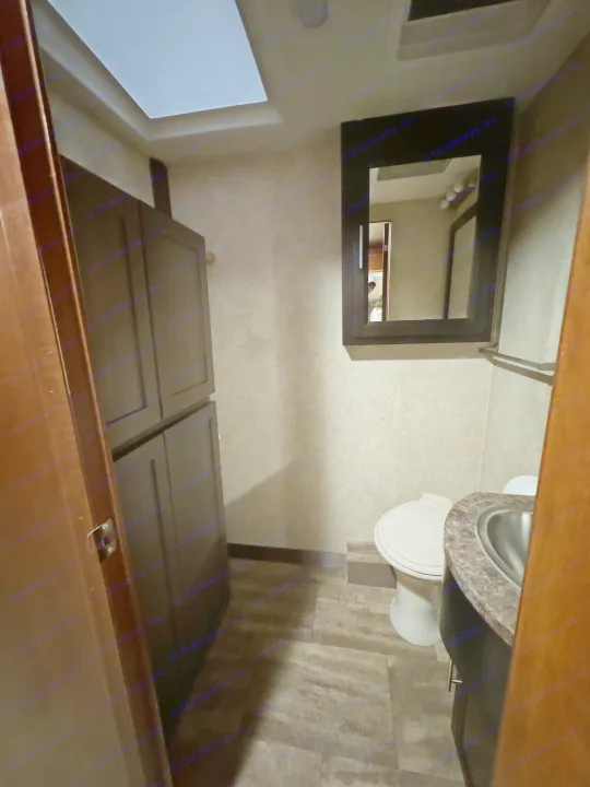 RV rental bathroom interior: Features a compact space with a toilet, sink, mirror, and built-in storage cabinets.. Forest River Georgetown 2018