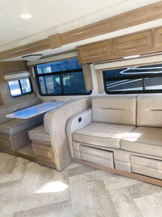 Spacious RV rental interior with a dinette, comfortable sofa, and overhead cabinets, perfect for your next adventure.. Forest River GEORGETOWN GT5 2019