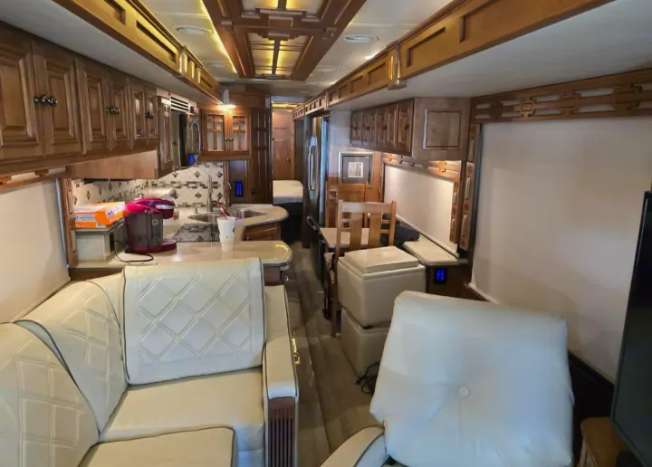 Experience luxury travel! This RV rental showcases a full kitchen, dining space, and comfortable living area with a bed in back.. Winnebago Ellipse 2016