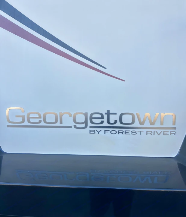 Detailed view of a "Georgetown by Forest River" RV's side, showing metallic lettering and stripes, great for rv rental.. Forest River GEORGETOWN GT5 2019