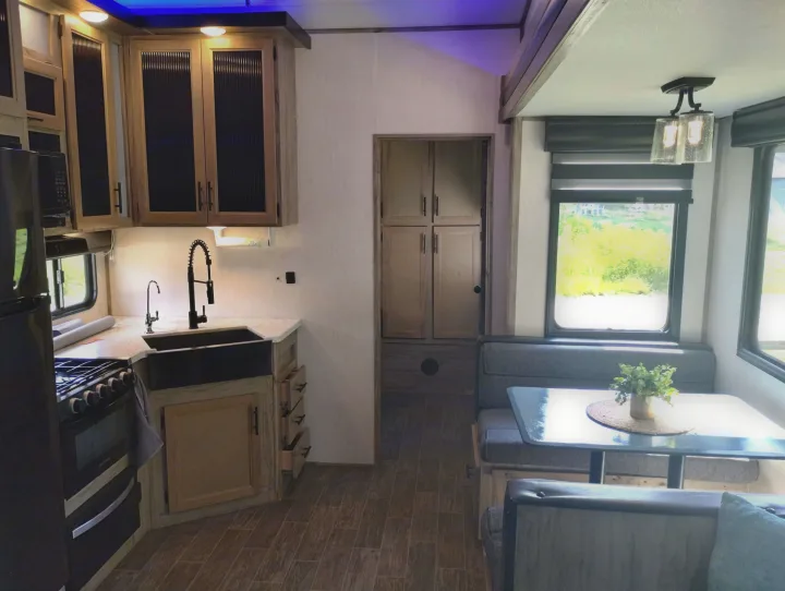 Spacious RV rental interior featuring a modern kitchen, dining area, and pantry, ideal for comfortable travel.Spacious RV rental interior featuring a modern kitchen, dining area, and pantry, ideal for comfortable travel.. Forest River Cherokee Arctic Wolf 2021