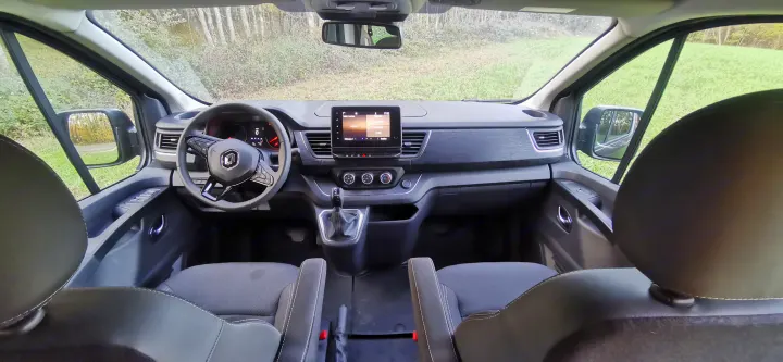 Inside a modern RV rental van: driver's view of dashboard, steering wheel, and infotainment screen at 5:02 PM.. Renault TRAFIC 2023