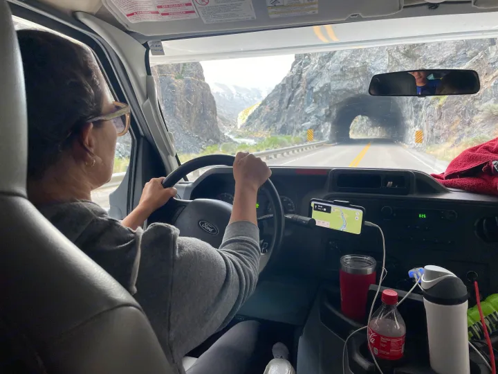 Driving an RV rental through a scenic mountain road, approaching a tunnel, with navigation on a Ford dashboard.. Thor Majestic 2019
