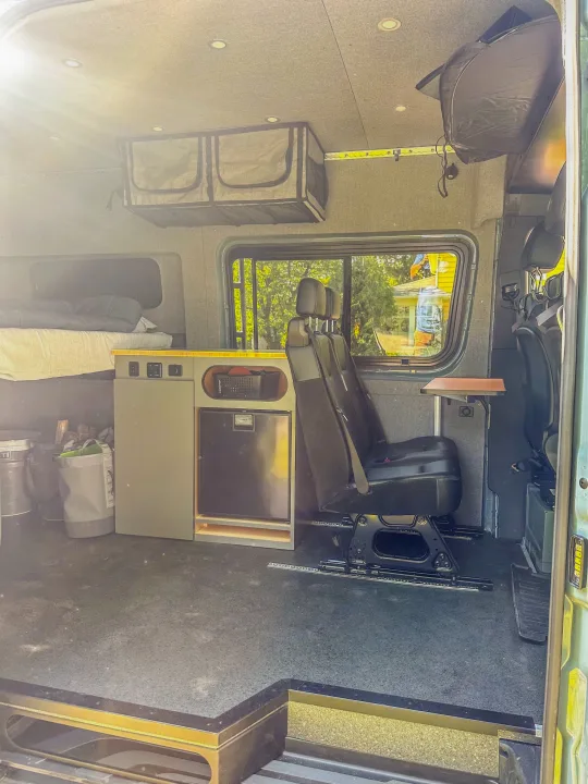 Inside a modern **rv rental** van: bed, kitchen counter with fridge, adjustable seats, and ample storage, ready for adventure.. Mercedes-Benz Sprinter 2024