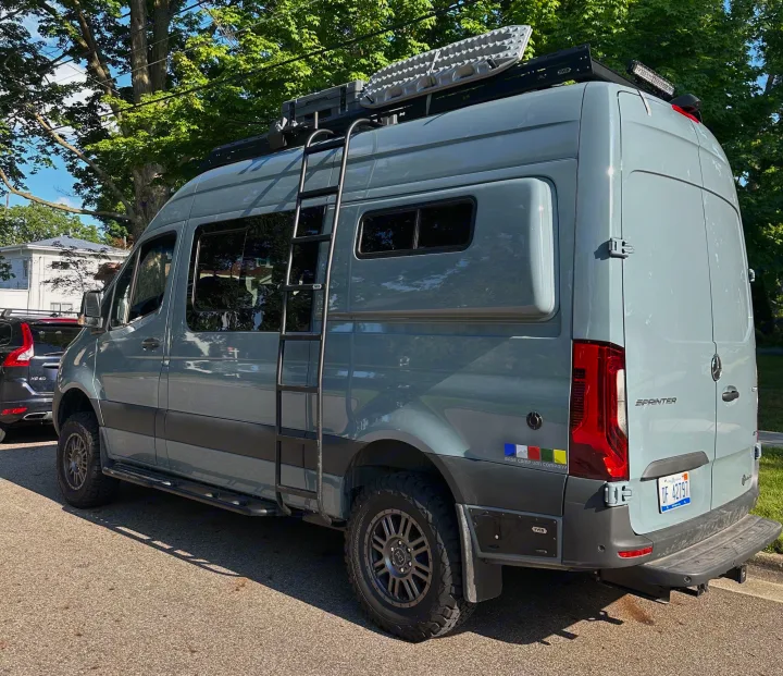 This customized gray Mercedes Sprinter **camper van**, perfect for an **rv rental** adventure, shows off its roof rack & ladder.. Mercedes-Benz Sprinter 2024