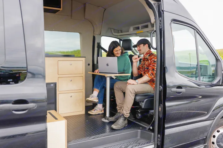 RV rental: Couple working remotely in a cozy camper van, enjoying mobile office life together.. Ford Transit 2020