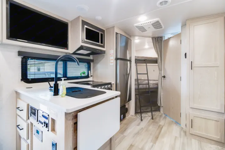 Step inside this clean rv rental, featuring a full kitchen, TV, and cozy bunk beds. Modern light wood interior.. Forest River Flagstaff Micro Lite 2022