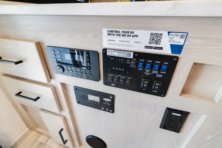 Smart RV interior control panel in an rv rental, showing a stereo, water, lights, and slide-out controls for easy travel.. Forest River Flagstaff Micro Lite 2022