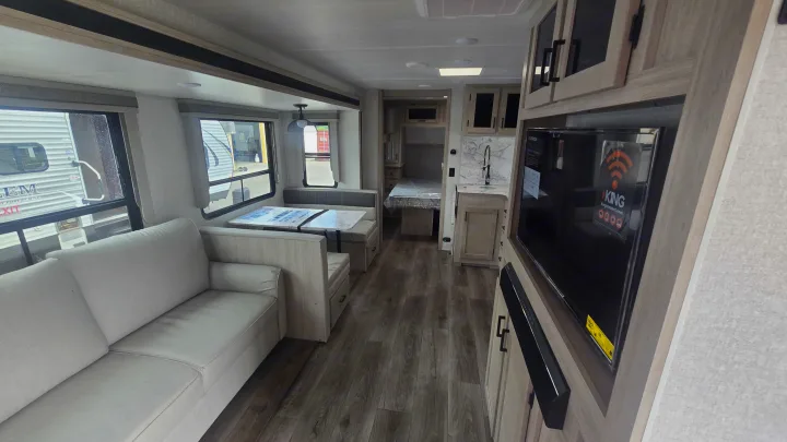 Explore this modern RV rental interior: sofa, dinette, kitchenette, bedroom, and entertainment center with TV. Ready for adventure.. East to West Alta 2022