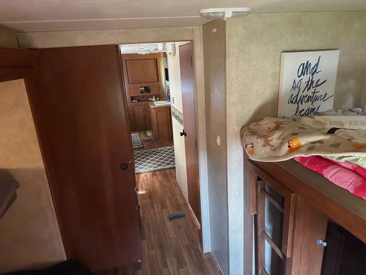 Spacious RV rental interior featuring a hallway, kitchen, and cozy bunk beds. Ready for your adventure!. Forest River Wildwood 2012