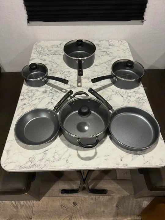 A full set of non-stick pots, pans & lids, ready for cooking in this RV rental kitchen.. Dutchmen Coleman 17B 2024