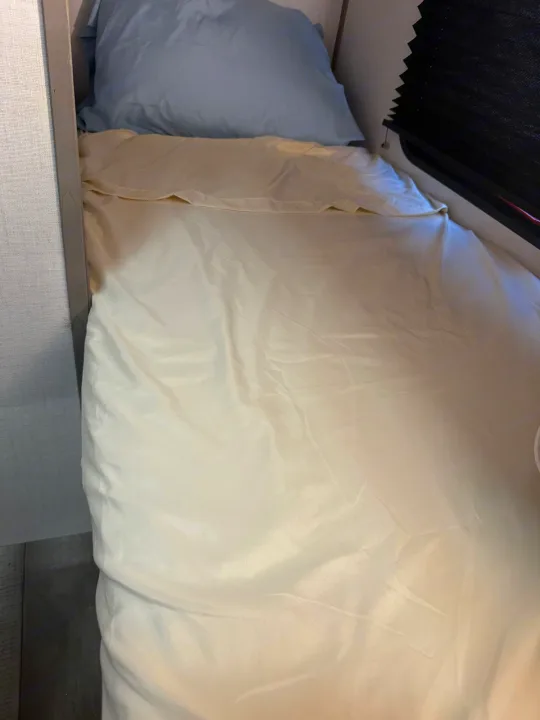 Cozy bunk bed with light bedding and pillow in an RV rental, offering comfortable sleeping quarters.. Dutchmen Coleman 17B 2024