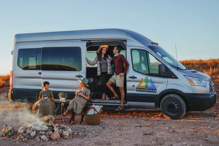 RV rental: A family enjoys camping and van life with their silver Wandervans camper van at sunset.. Ford Transit 350 2021