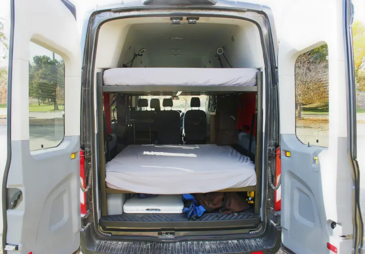 Inside this RV rental van, two comfortable bunk beds offer flexible sleeping for your next adventure.. Ford Transit 350 2021
