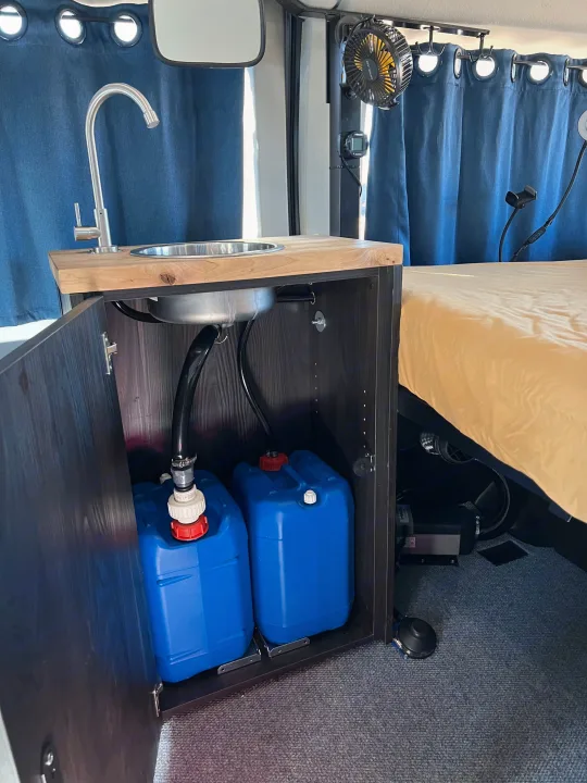This RV rental offers a clever kitchenette with sink, hidden water tanks, and a cozy bed for comfortable travel.. Ford transit 2019