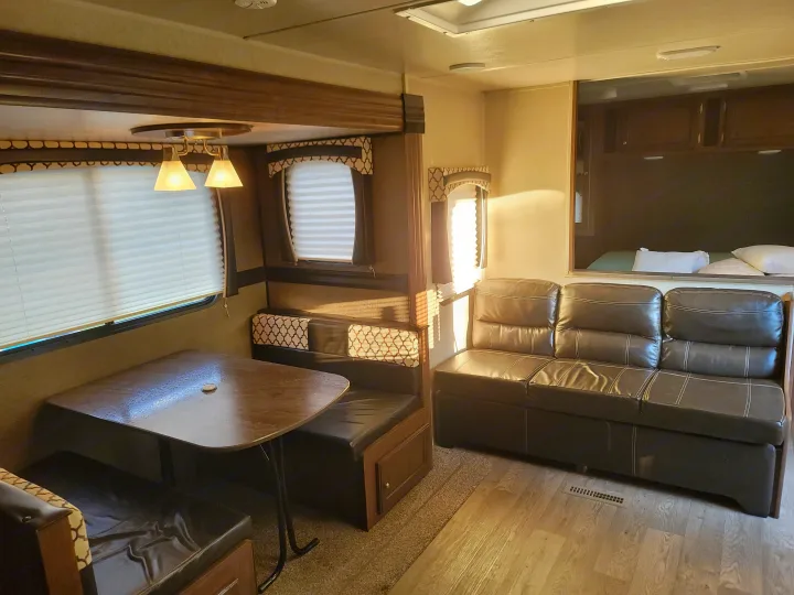 Spacious RV rental interior featuring a comfortable dinette, sofa, and bedroom area. Perfect for your next adventure.. Heartland RVs Prowler 2018