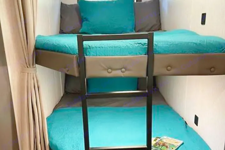 RV rental bunk beds: Space-saving design with teal bedding and a ladder for comfortable sleeping.. Forest River Salem Cruise Lite 2023