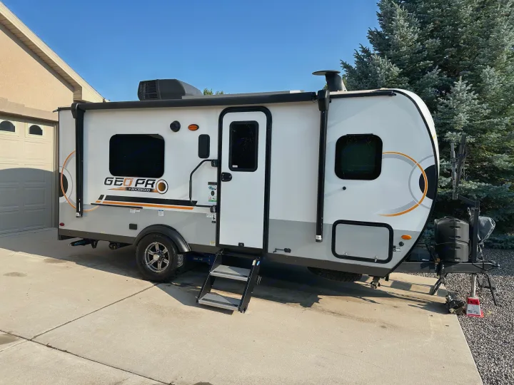 A modern RV, a Geo Pro travel trailer, ideal for an RV rental, parked on a driveway with steps out.. Forest River GeoPro 2022