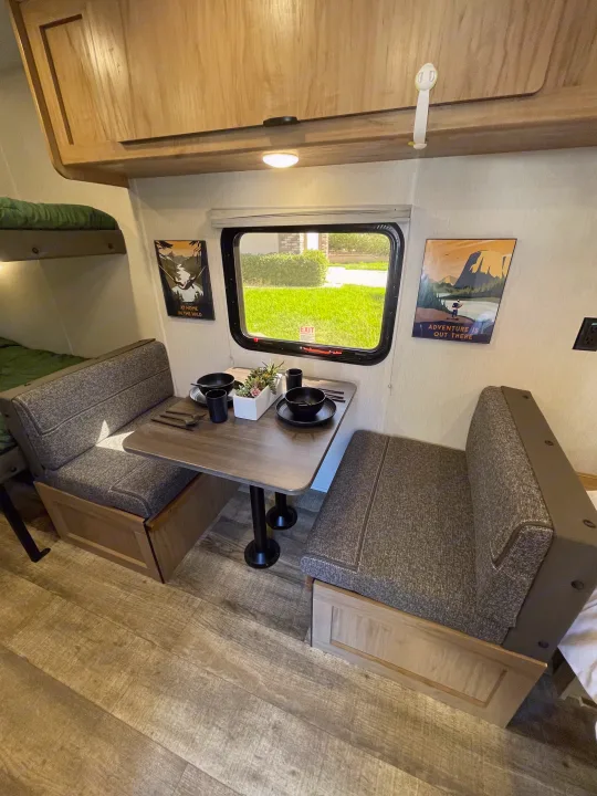 Cozy rv rental interior featuring a dinette with bunk beds and overhead storage, ready for adventure.. Forest River Wolf Den 16EV 2024