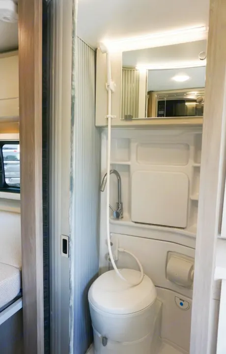 Inside an RV rental: a compact wet bath with a toilet, shower, and sink, designed for efficient mobile living.. Thor Tellaro 2022