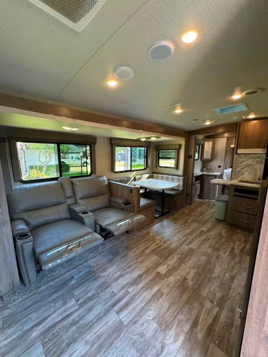 RV rental: Bright, modern interior featuring comfy recliners, dinette, and a well-equipped kitchen space.. Grand Design Imagine 2022