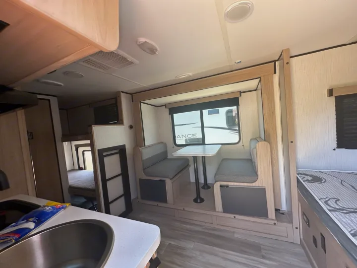 Explore this RV rental's modern interior: light wood dinette, kitchen sink, and bunk beds. Your adventure awaits!. Cruiser RV Hitch 2022