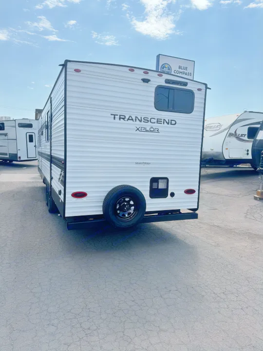 White Transcend XPLOR travel trailer for rv rental, parked at a Blue Compass RV dealership.. Grand Design Transcend Xplor 2024