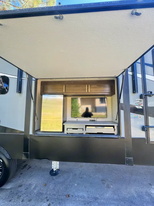 RV rental with outdoor entertainment: TV, fridge, and storage in an open hatch for your camping adventures.. Keystone Raptor 2020