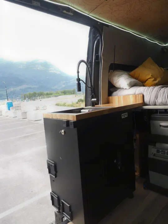 RV rental's custom van interior: mobile kitchen with sink, cozy bed, mountain views. Ideal for van life.. Mercedes Sprinter 2016