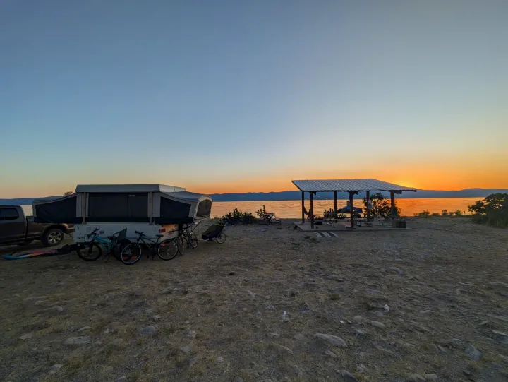 Enjoying a serene sunset camping experience with an RV rental, bikes, and lakeside picnic shelter.. Fleetwood Sedona 2004