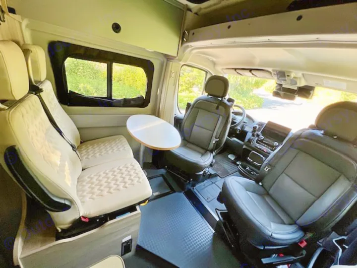 Spacious RV rental interior: swivel front seats, rear bench seating, and a dinette table for comfortable travel.. Winnebago Winnebago 2023