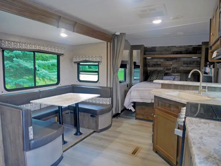 Modern RV rental interior featuring a spacious dinette, full kitchen, and comfortable bedroom for road trips.. Dutchmen Aspen Trail 2020