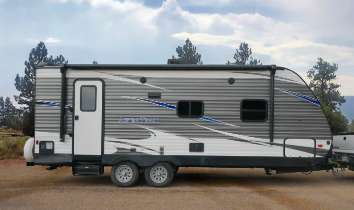 Grey & white Aspen Trail travel trailer, an ideal RV rental for your next outdoor adventure.. Dutchmen Aspen Trail 2020
