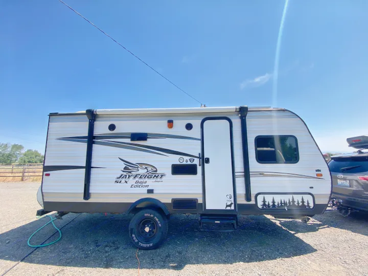 Jayco Baja Edition travel trailer, perfect for your next RV rental adventure, parked on gravel under a clear sky.. Jayco Jay Flight SLX 2016