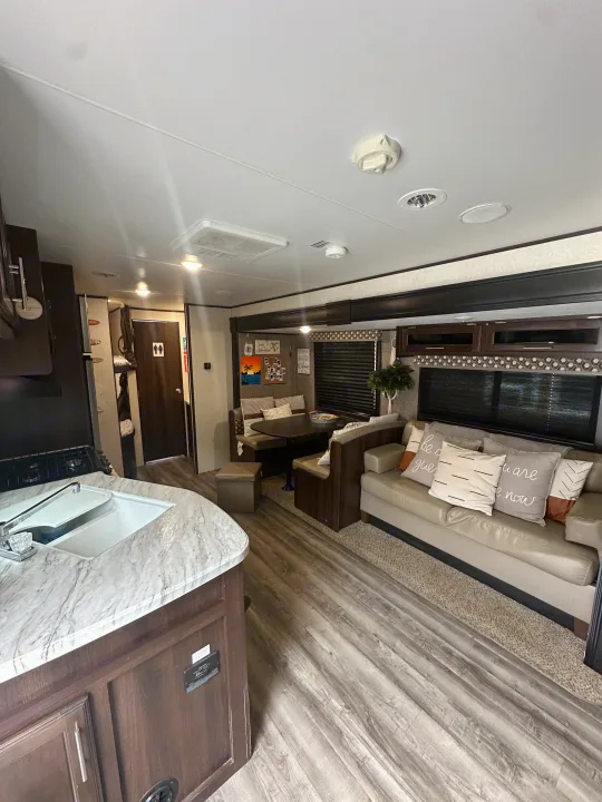 This cozy RV rental offers a well-equipped kitchen, comfortable dinette, and living area, with bunks visible. Perfect for travel!. Jayco Jay Flight SLX 2019