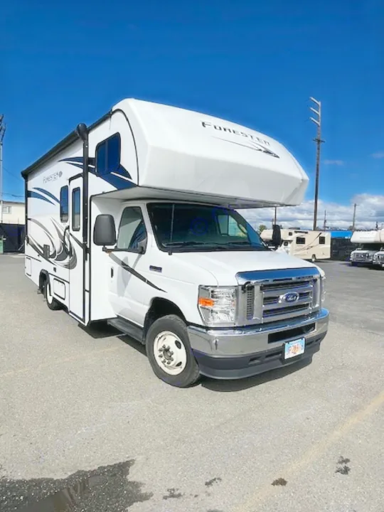 White Forester Class C RV rental on a Ford chassis, parked on asphalt. Ready for your next road trip adventure.. Forest River Forester 2022
