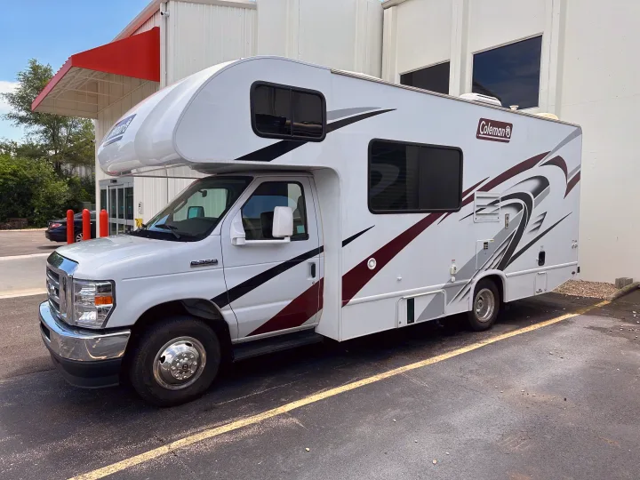 White Coleman Class C RV rental, featuring striking graphics, parked and ready for your next adventure.. Thor Coleman 2021