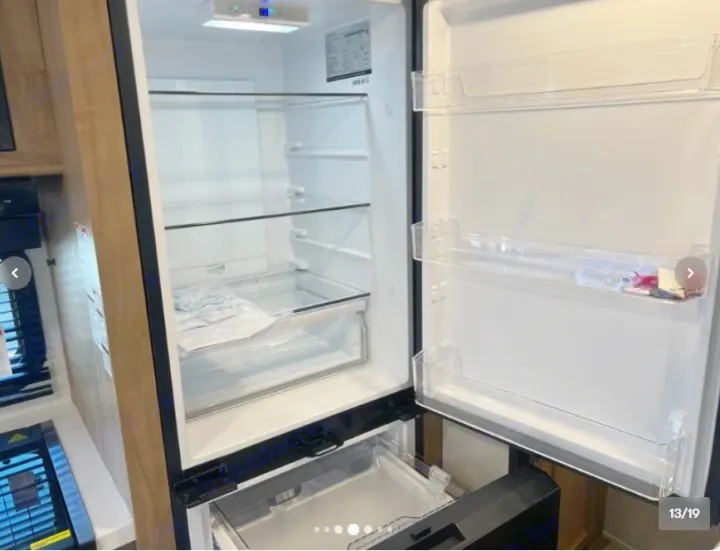 Inside look at the clean, empty refrigerator and freezer drawer of an RV rental. Plenty of food storage space.. Forest River Cherokee Wolf Pup 16KHWBL 2024