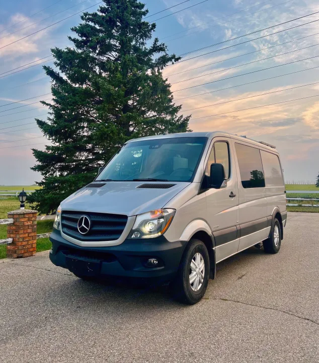 Silver Mercedes-Benz Sprinter van rv rental, parked by a tree and fence. Ready for your next adventure.. Mercedes Sprinter 2016