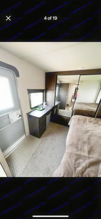 RV rental interior showing a cozy bedroom with a desk, window, mirrored closet, and plush bed.. Forest River Salem 2018