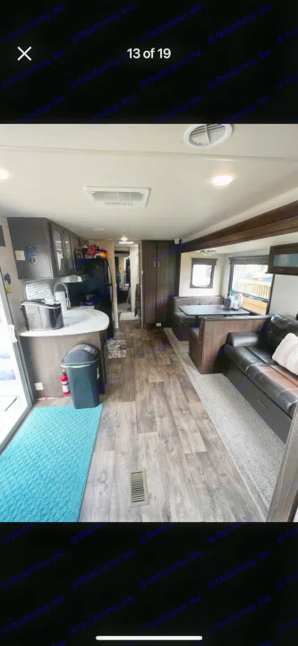 Spacious RV rental interior featuring a full kitchen, comfortable dining booth, and living area with wood laminate flooring. Ideal for travel.. Forest River Salem 2018