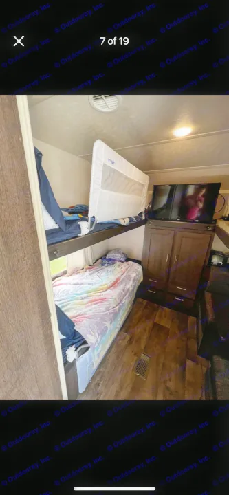 RV rental interior features bunk beds with a safety rail, colorful bedding on the lower bunk, and a TV cabinet.. Forest River Salem 2018