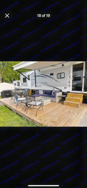 An inviting RV rental with a large attached wooden deck, outdoor seating, and steps for easy access.. Forest River Salem 2018
