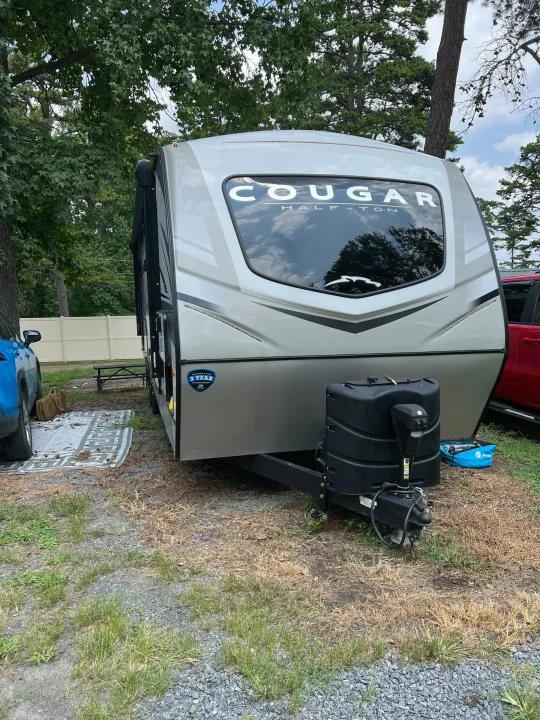 This Cougar Half-Ton RV rental is parked at a campsite, ready for adventure. Ideal for outdoor recreation.. Keystone RV Cougar 2023